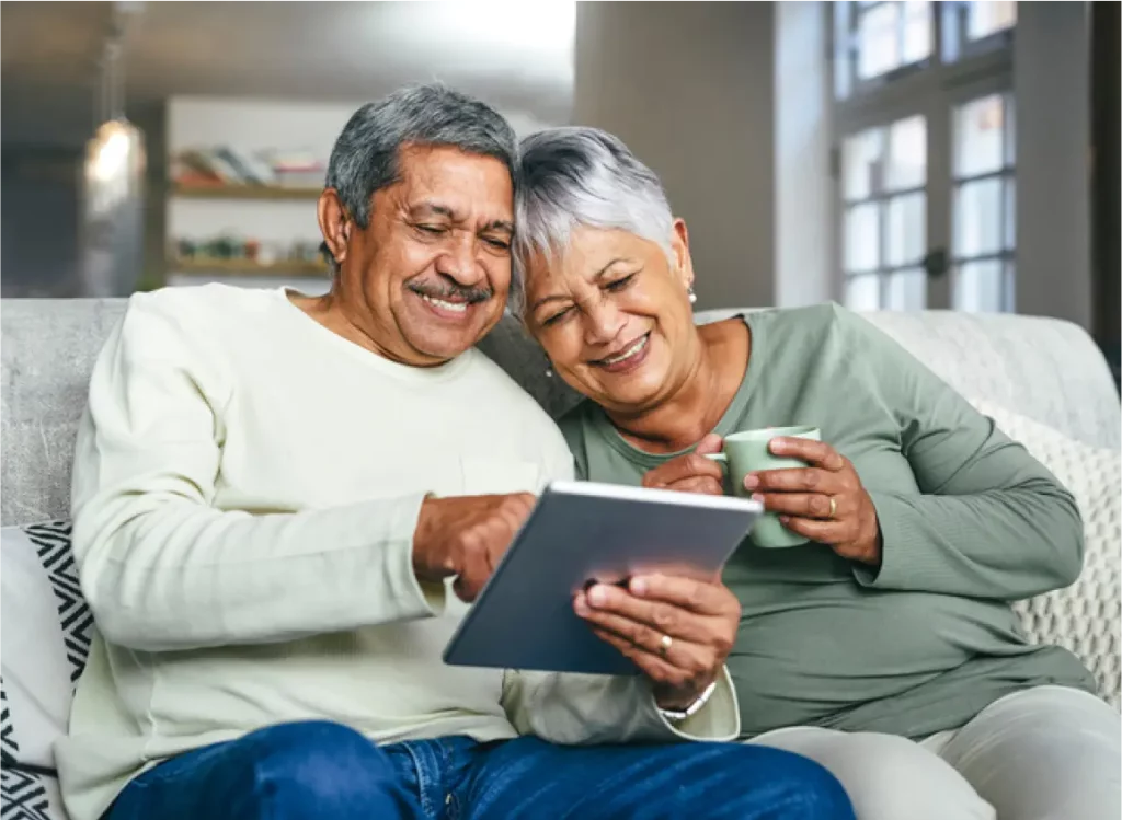 Husband and wife looking at tablet smiling