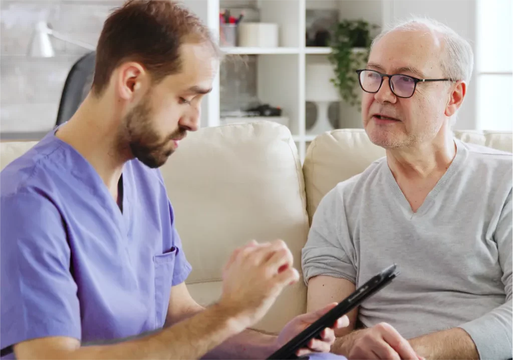 Photo of Nurse on tablet doing in-home assesment with post operation patient