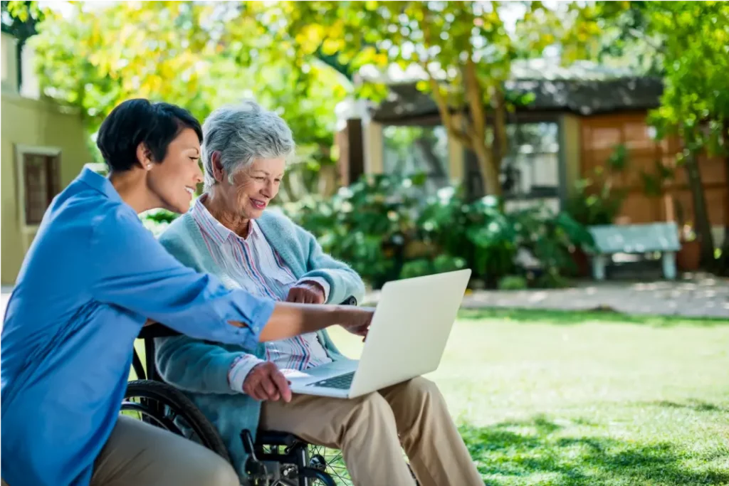 Nurse helping senior on computer in senior home