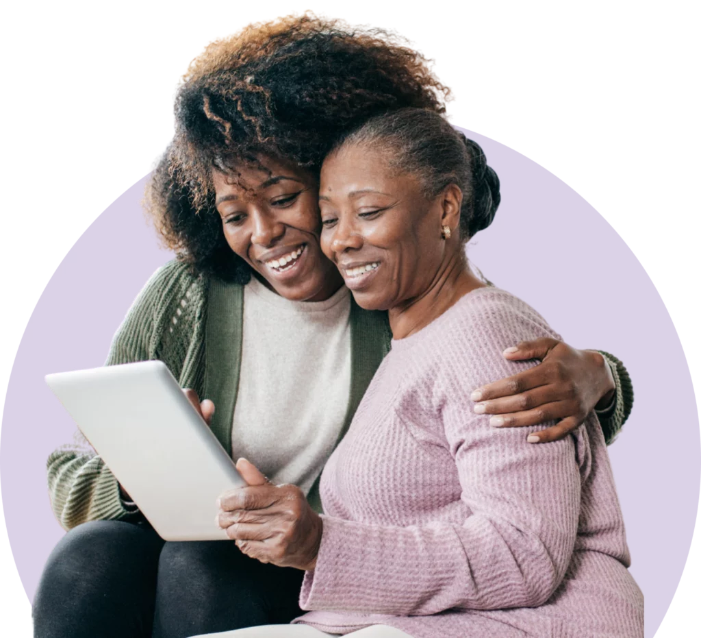 Daughter and mother looking at tablet smiling